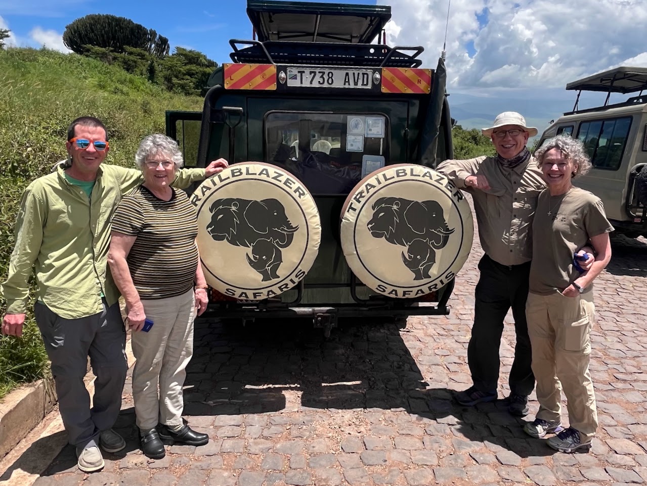 Tech Alumni on safari pose with the Trailblazers jeep
